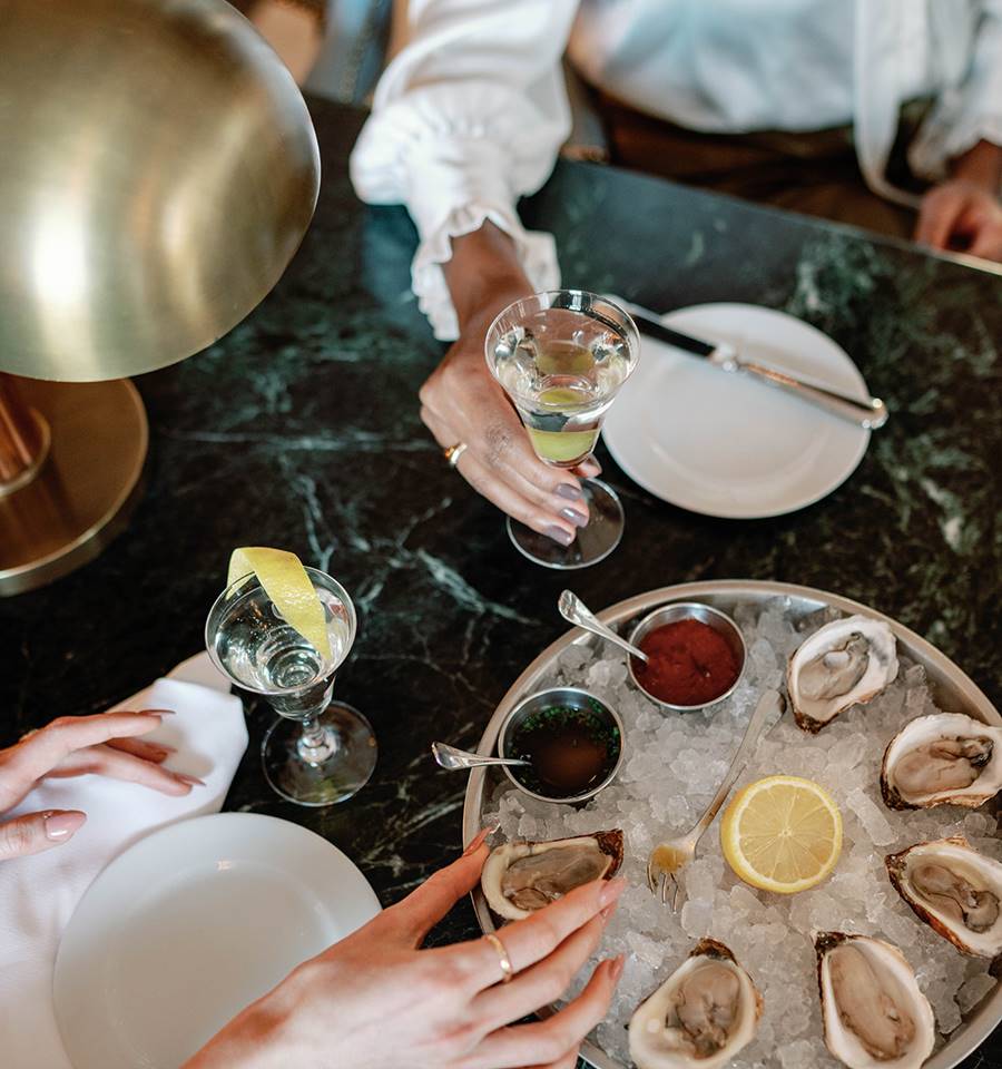 An elegantly decorated lounge area at Riggs DC, featuring friends enjoying their drink and appetiser together.