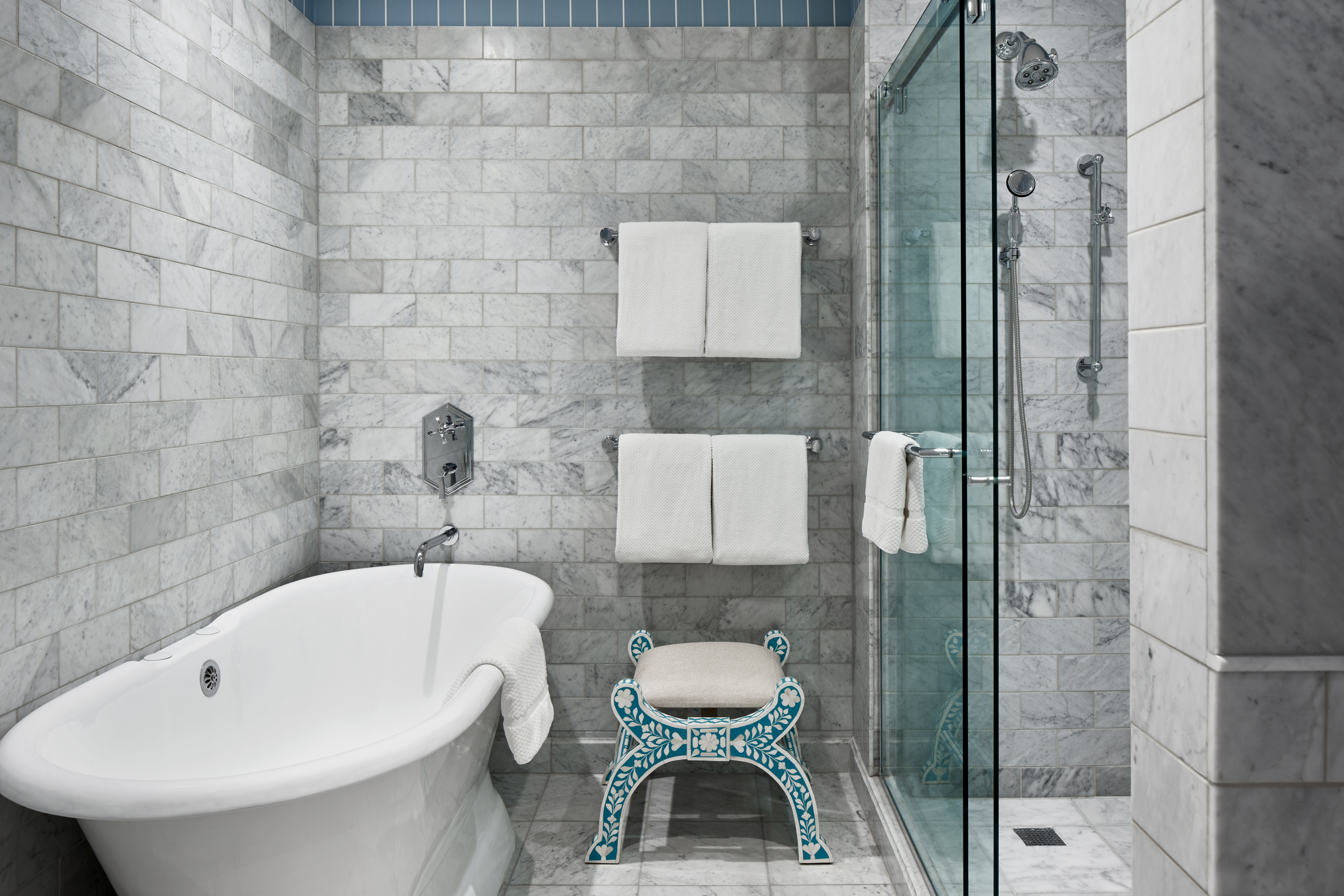 A white bathtub in the Caroline Harrison suite's gorgeous bathroom, featuring modern design and luxurious tiled fixtures.
