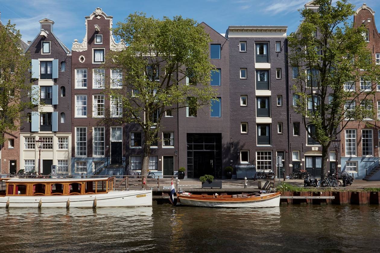 Pulitzer Amsterdam hotel is comprised of a row of traditional canal houses with large windows and decorative gables.