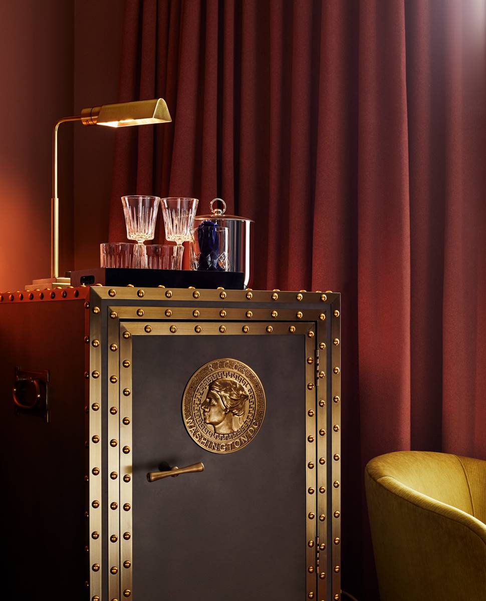 A vintage vault in an elegantly designed room showcases a minibar with drinks and clean glasses.