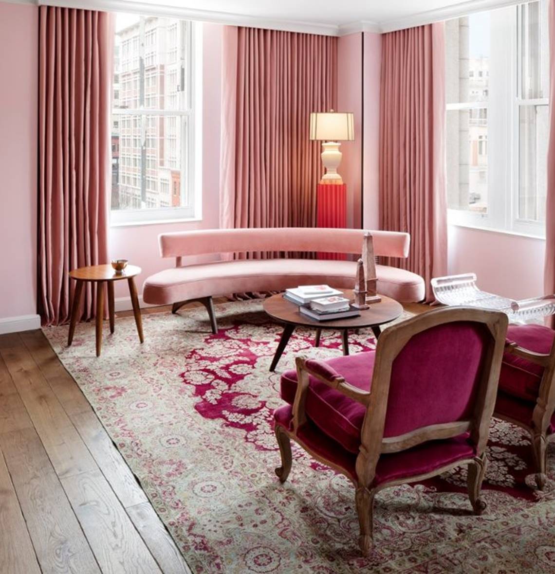 The living room of the First Lady Ida McKinley suite, with refined decor and rose pink plush furnishings.