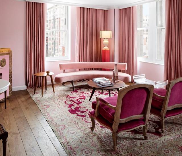 The living room of the First Lady Ida McKinley suite, with refined decor and rose pink plush furnishings.