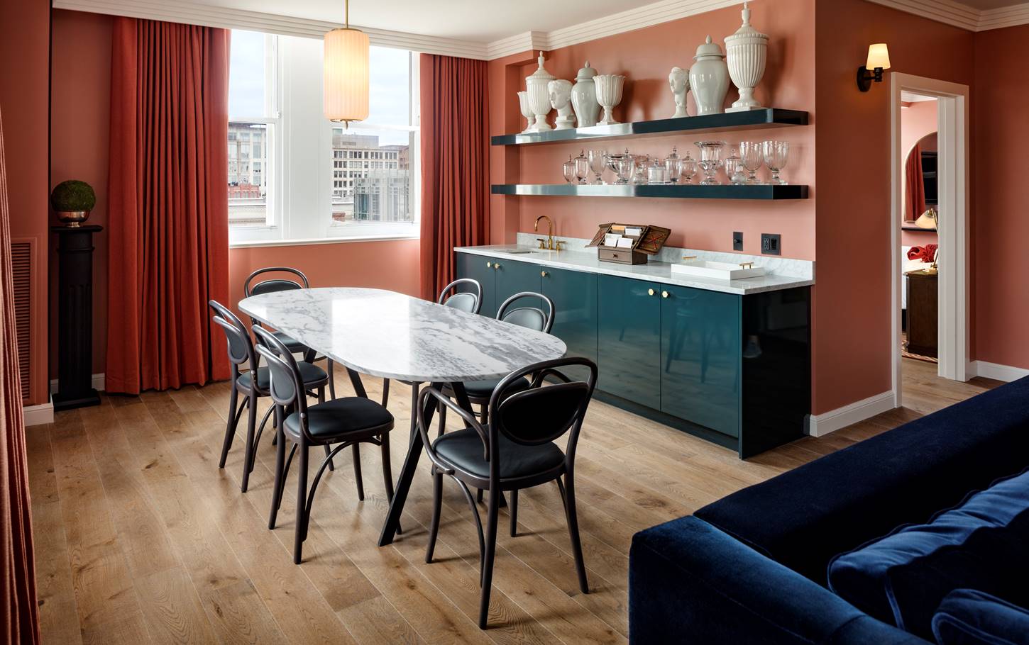 An elegant dining table in the Gallery Suite at Riggs DC, with sophisticated decor and marble art pieces on the shelves.