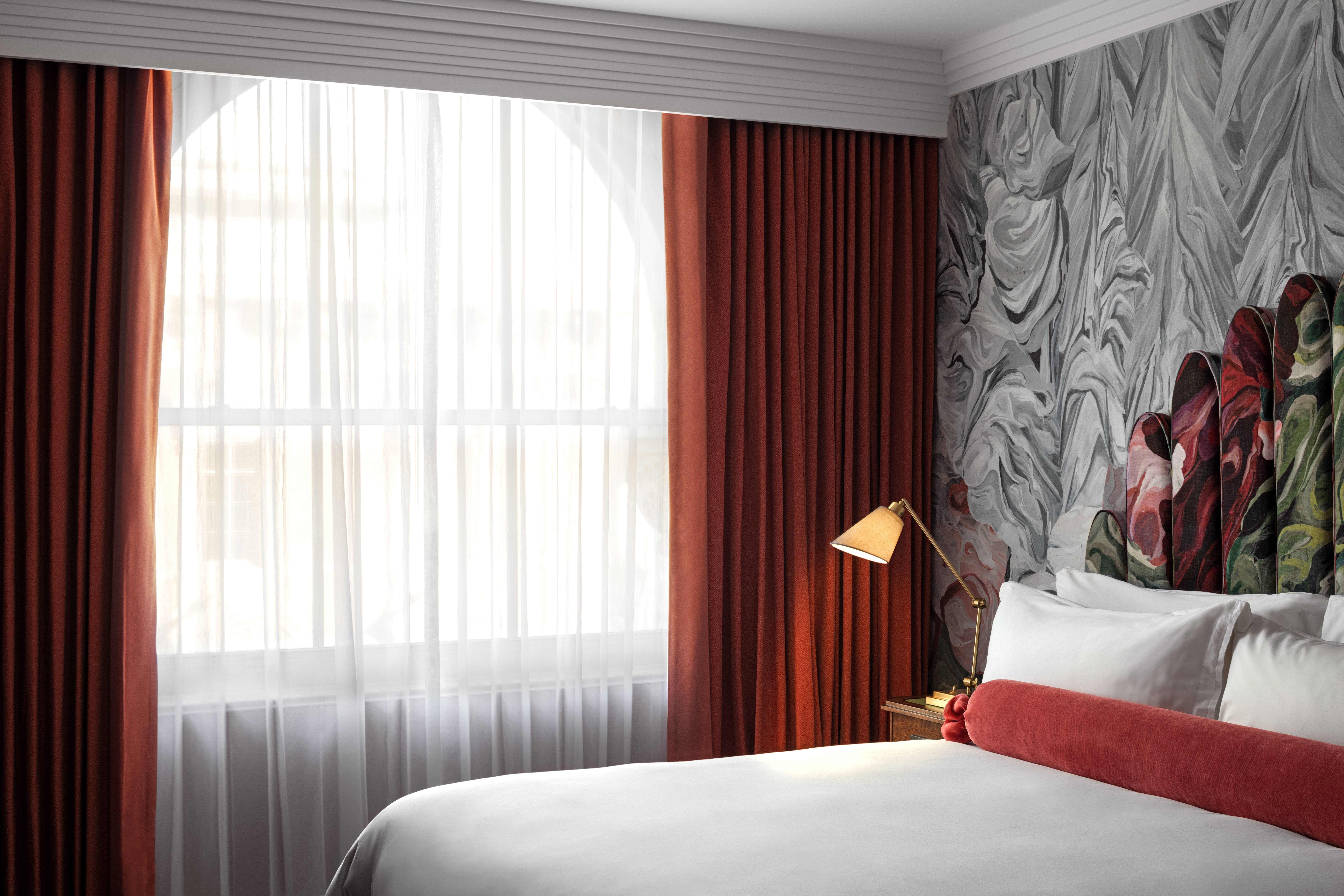 A classic room at Riggs DC, featuring elegant decor, a comfortable bed, and large windows with natural light.