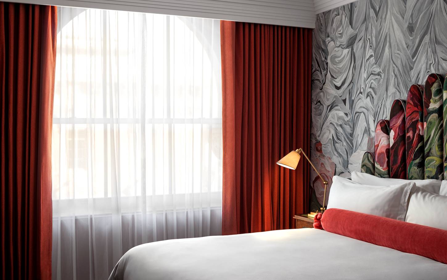 A classic room at Riggs DC, featuring elegant decor, a comfortable bed, and large windows with natural light.