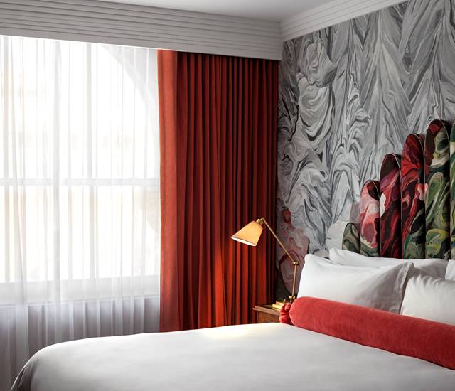 A classic room at Riggs DC, featuring elegant decor, a comfortable bed, and large windows with natural light.