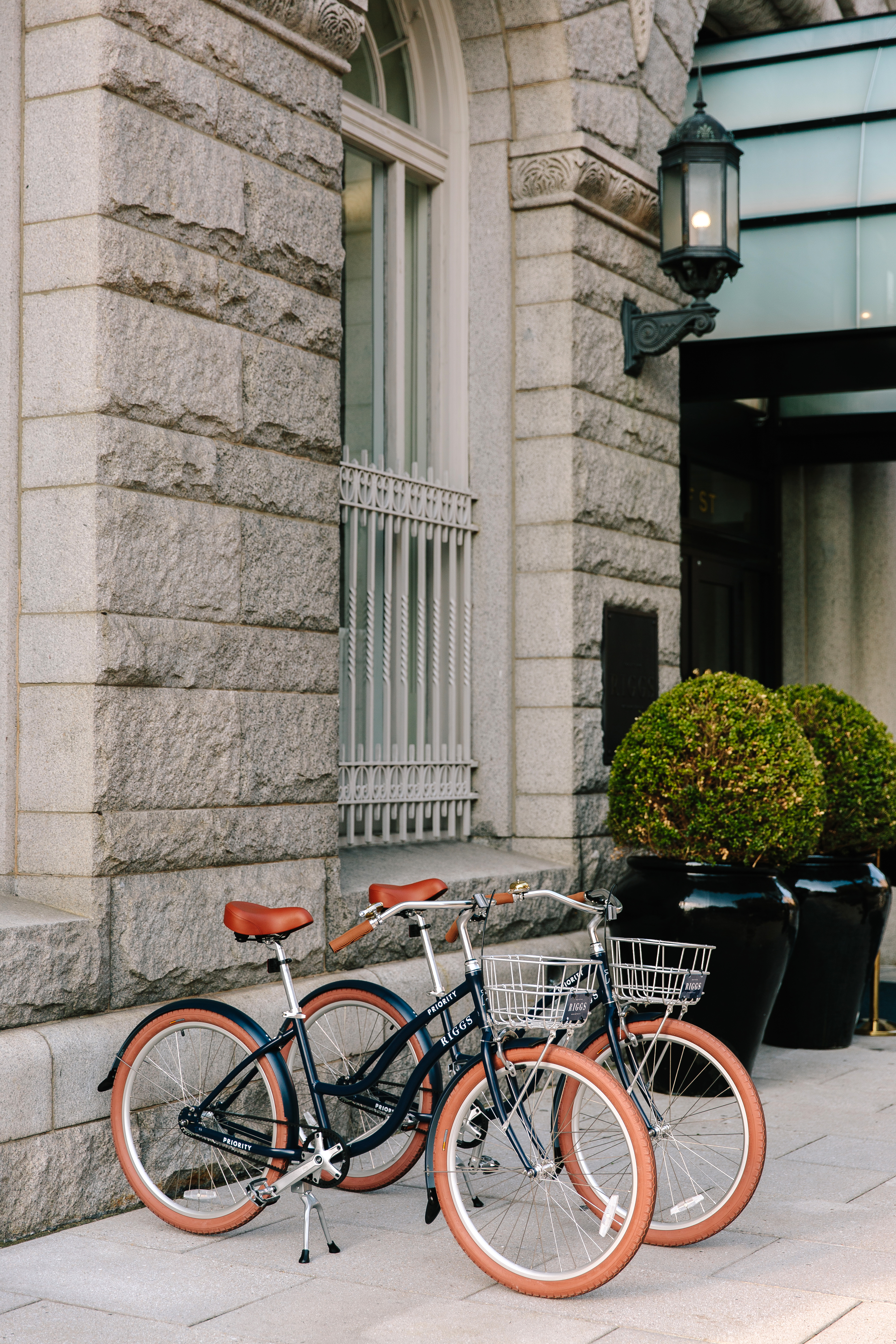 A close-up view of stylish bikes available for guests at Riggs DC, set against a the hotels walls.