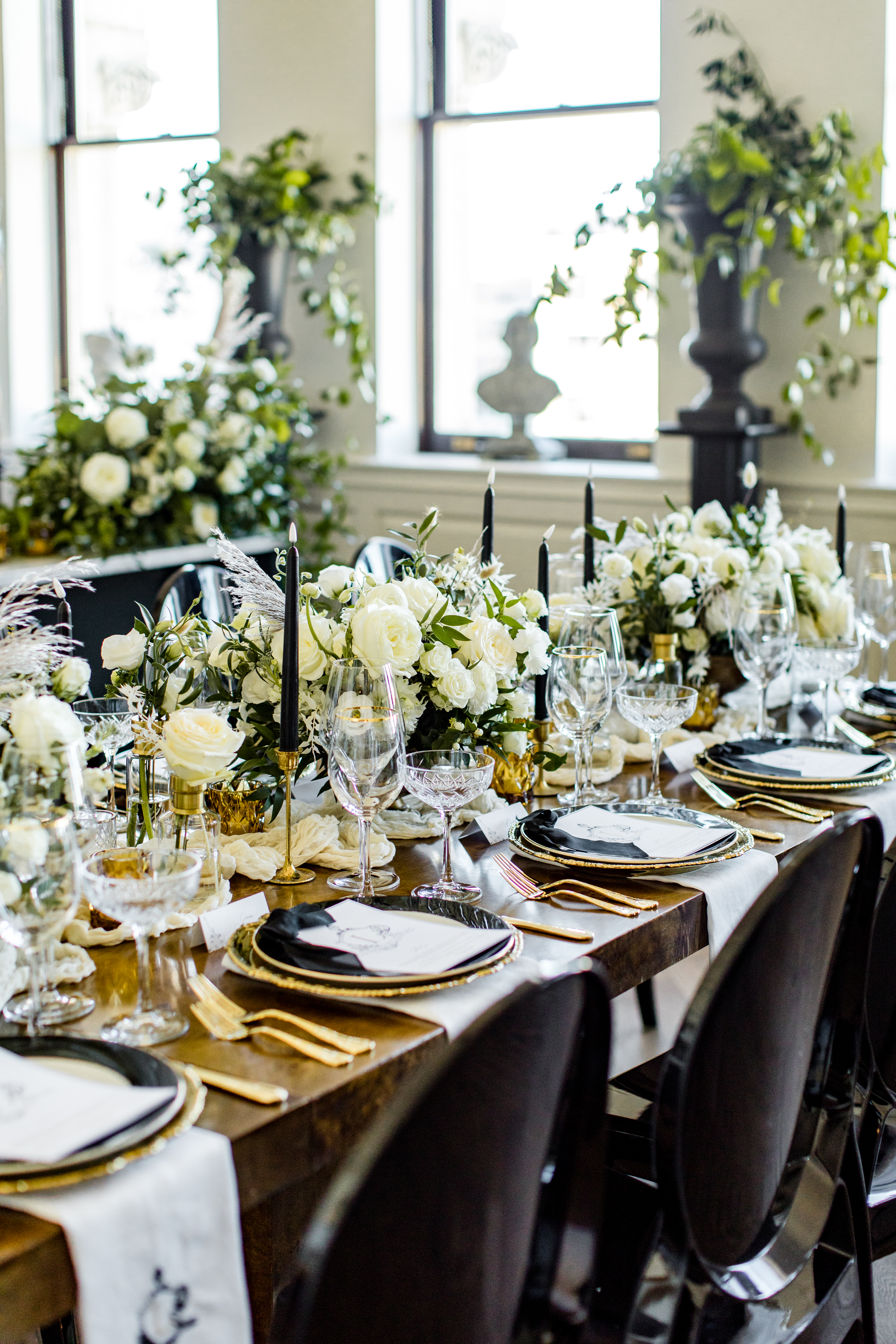 Opulent table setting with white flowers, black candles, and crystal glassware at a wedding at the Riggs DC hotel.