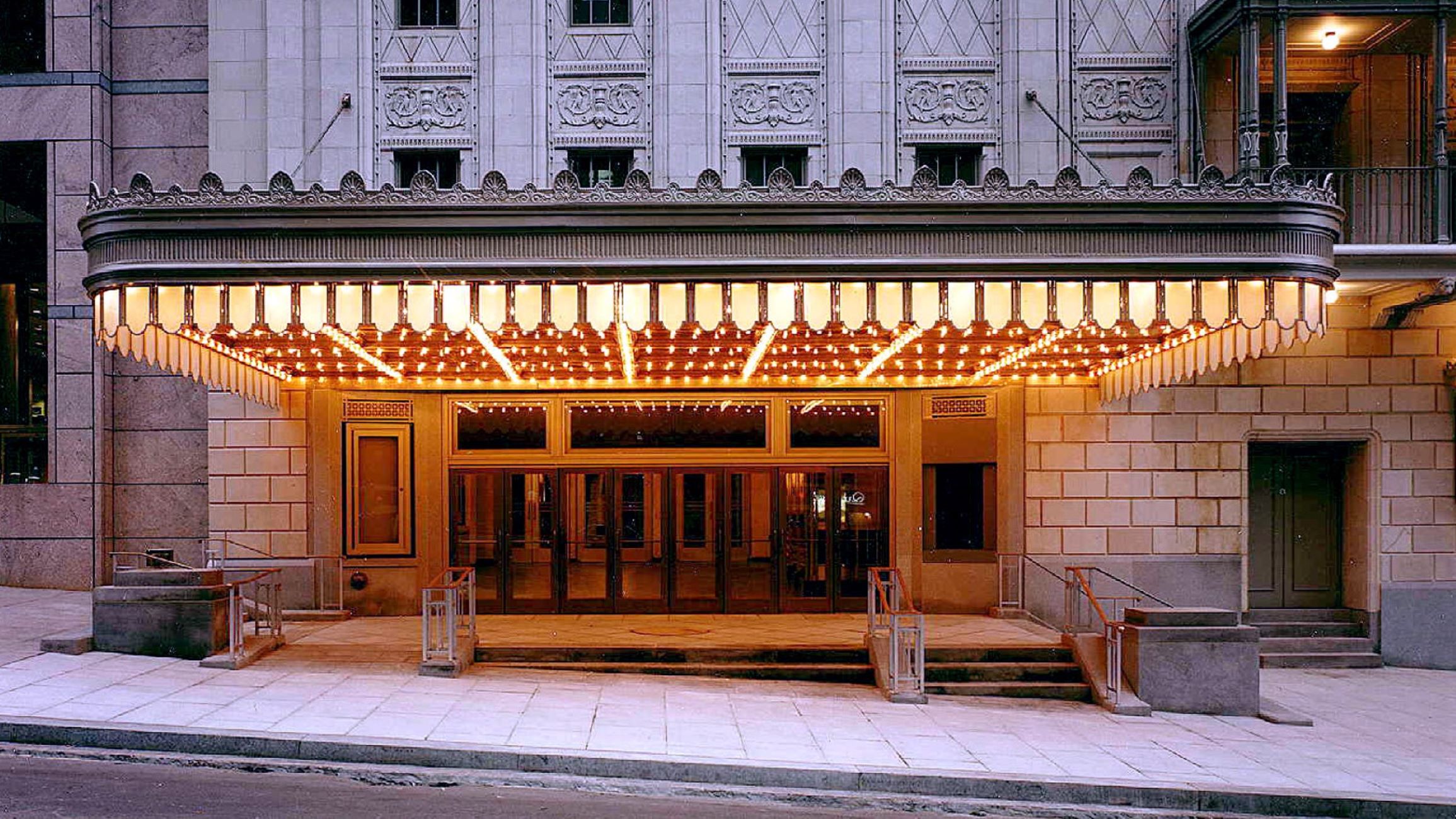 A stone building with a lit canopy over the entrance