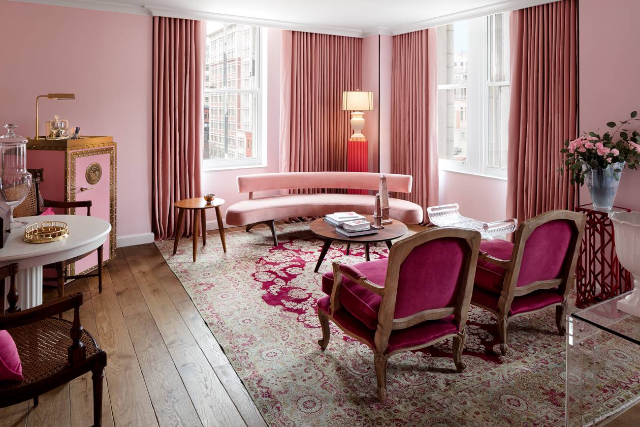 The living room of the First Lady Ida McKinley suite, featuring rose pink decor, floral arrangements and plush furnishings.