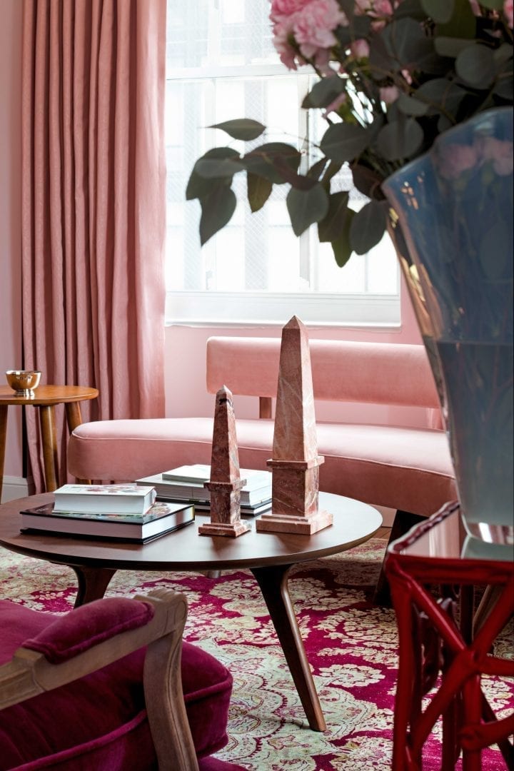An elegantly decorated living room detail at the Ida McKinley Suite at Riggs DC, featuring stylish pink decor and artwork.