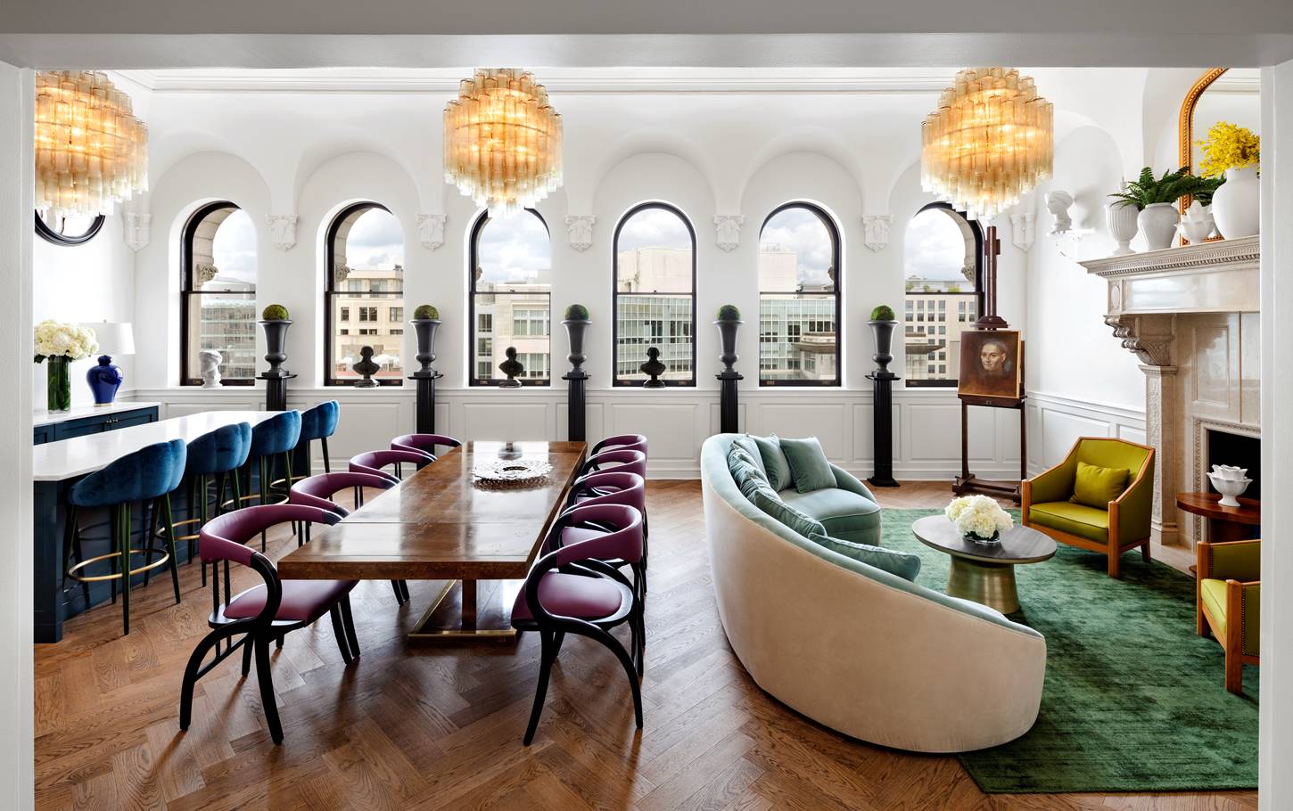 The Riggs Suite, showcasing a spacious layout with luxurious furnishings, three chandeliers and modern decor.